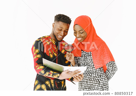 African students in traditional clothes with book in white studio African students in traditional clothes with book in white studio 80850317