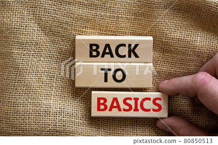 Wooden blocks form the words 'back to basics' on canvas background. Male hand. Business and educational concept. Wooden blocks form the words 'back to basics' on canvas background. Male hand. Business and educational concept. 80850513