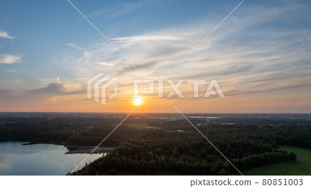 Aerial view shot by a drone of a beautiful dramatic and colorful sunset at coast of the lake. Nature 80851003