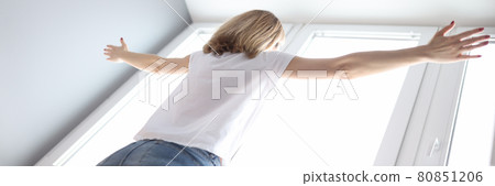 Woman standing at the window with her arms wide open 80851206