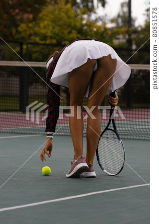 Attractive woman playing tennis on court Attractive woman playing tennis on court 80851578