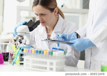 Team of scientists conducts laboratory research using microscope 80851849