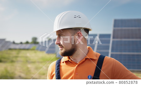 Portrait of male engineer in hard helmet turning head and looking to camera. Positive worker. Ecological industry. Solar farm concept. Concept for renewable energy, technology, future. 80852878