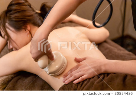 Women undergoing treatment at an esthetic salon (back / cavitation) 80854486