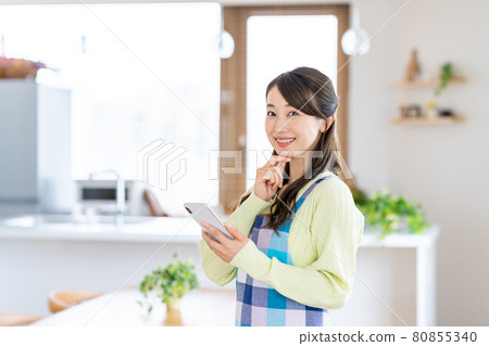 在餐廳/廚房使用智能手機的年輕家庭主婦 80855340