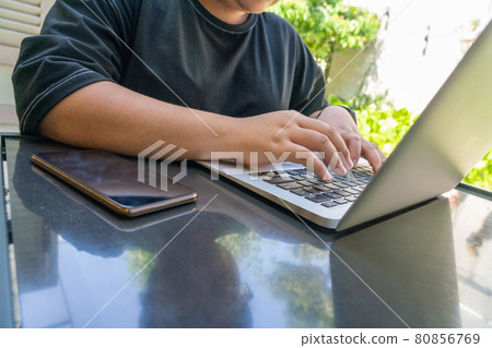 Working on laptop outdoors Working on laptop outdoors 80856769