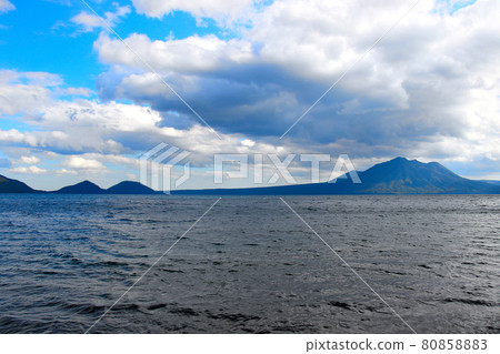 A wide view of Mt. Fuppushi and Mt. Tarumae from the coast of Lake Shikotsu A wide view of Mt. Fuppushi and Mt. Tarumae from the coast of Lake Shikotsu 80858883