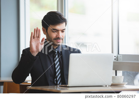 man raising hand to greet making video call on laptop. conference online. working new normal. man raising hand to greet making video call on laptop. conference online. working new normal. 80860297