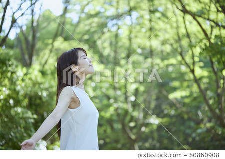 Young Japanese woman relaxing in the woods Young Japanese woman relaxing in the woods 80860908