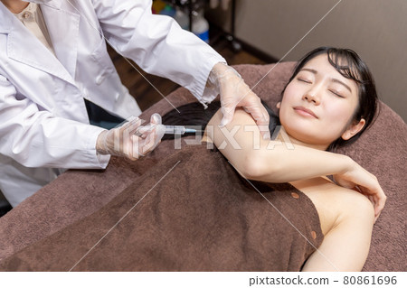 Women undergoing cosmetic surgery (fat dissolving injection, upper arm) 80861696