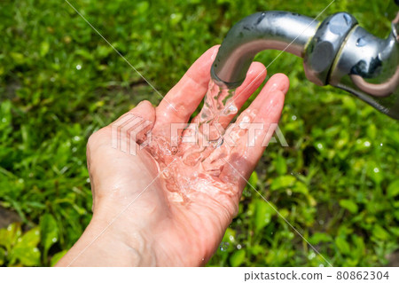 一隻手在公園裡接水龍頭里的水 80862304