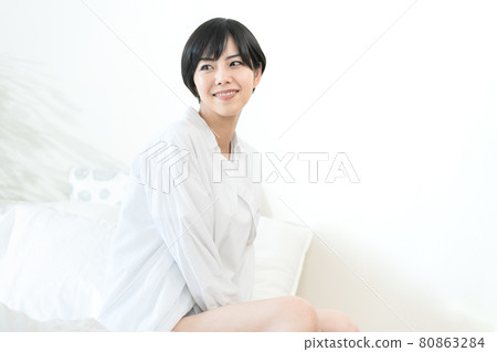 A woman sitting on the bed A woman sitting on the bed 80863284