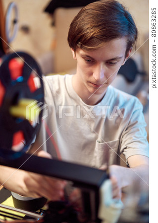 Young man set up 3d printer Young man set up 3d printer 80863285