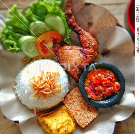 Fried chicken leg, tempeh, tofu, and salad. Traditional dish from West Java, Indonesia. Fried chicken leg, tempeh, tofu, and salad. Traditional dish from West Java, Indonesia. 80863645