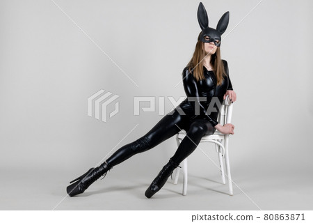 Sexy beautiful woman pole dancer posing in latex costume on background. Easter bunny concept. Sexy beautiful woman pole dancer posing in latex costume on background. Easter bunny concept. 80863871