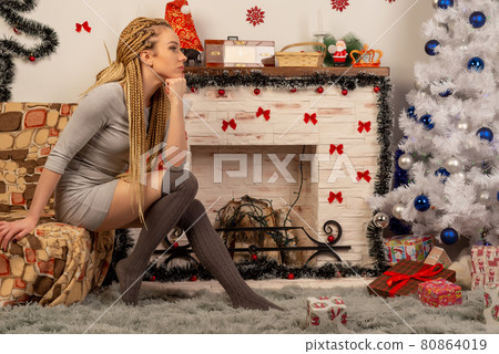 Happy young woman holding christmas present box Happy young woman holding christmas present box 80864019