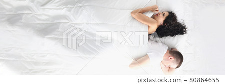 Sad man and woman lying with their backs to each other in bed top view Sad man and woman lying with their backs to each other in bed top view 80864655