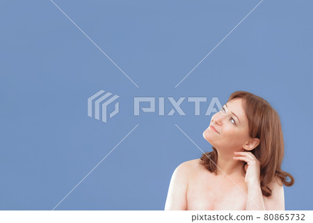 Naked woman applying anti-age cream on her skin isolated on color background. Pretty mature female applies skin care product by touching face with hand. Close up. Spa and wellness concept. Template Naked woman applying anti-age cream on her skin isolated on color background. Pretty mature female applies skin care product by touching face with hand. Close up. Spa and wellness concept. Template 80865732