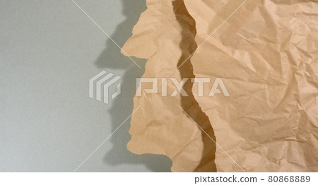 mint brown piece of paper with torn edges and shadow on gray background. Abstract creative backdrop for designer 80868889