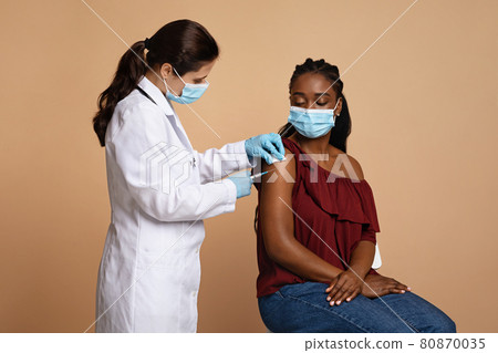 Black lady patient in face mask getting vaccination Black lady patient in face mask getting vaccination 80870035