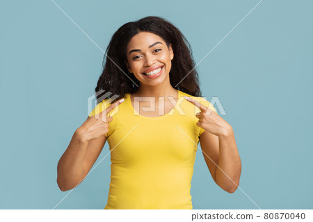 Teeth alignment and whitening concept. Happy african american woman pointing at her wide smile, blue background Teeth alignment and whitening concept. Happy african american woman pointing at her wide smile, blue background 80870040