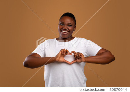Portrait of casual young black woman shaping hands like heart Portrait of casual young black woman shaping hands like heart 80870044