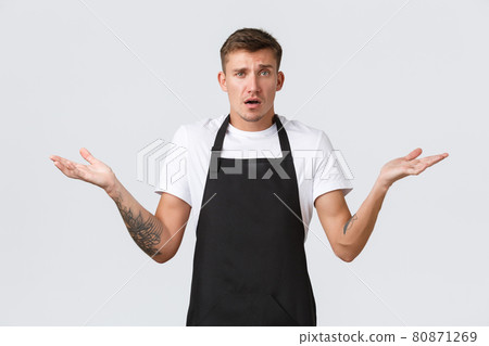 Small business owners, coffee shop and staff concept. Indecisive worried part-time worker, cafe barista in black apron, spread hands sideways and shrugging shoulders confused, dont know Small business owners, coffee shop and staff concept. Indecisive worried part-time worker, cafe barista in black apron, spread hands sideways and shrugging shoulders confused, dont know 80871269