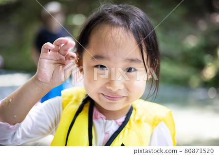 Girl enjoying playing in the river Girl enjoying playing in the river 80871520