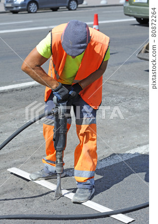 Worker preparing lay for asphalting the road on the street using pneumatic road breaker Worker preparing lay for asphalting the road on the street using pneumatic road breaker 80872264