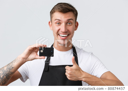 Cafe and restaurants, coffee shop owners and retail concept. Cheerful handsome salesman, store clerk in black apron showing thumbs-up in approval, recommend paying for credit card Cafe and restaurants, coffee shop owners and retail concept. Cheerful handsome salesman, store clerk in black apron showing thumbs-up in approval, recommend paying for credit card 80874437