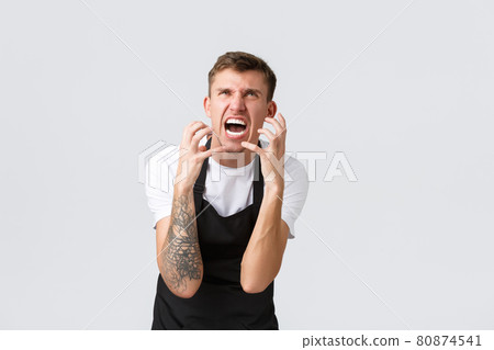 Employees, grocery stores and coffee shop concept. Hateful and angry, pissed-off barista in cafe, worker in black apron losing temper, clench hands into fists mad, grimacing and shouting in rage Employees, grocery stores and coffee shop concept. Hateful and angry, pissed-off barista in cafe, worker in black apron losing temper, clench hands into fists mad, grimacing and shouting in rage 80874541