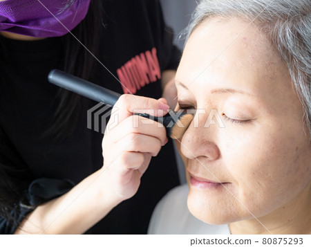 Senior asian woman and make up artist. Senior asian woman and make up artist. 80875293