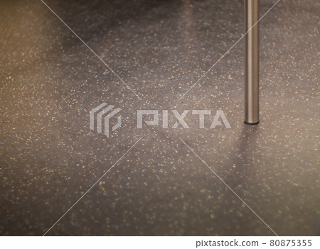The base of steel pole on the subway train floor 80875355