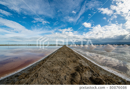 Afternoon saline with bright sky On the left side is salt that starts with crystals mixed in water. The right side is the salt that has crystals and as a pile to collect. 80876086