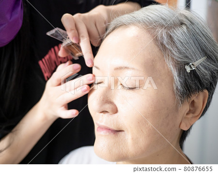 Senior asian woman and make up artist. Senior asian woman and make up artist. 80876655