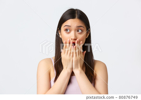 Beauty, fashion and people emotions concept. Shocked startled asian girl gasping, open mouth and cover it with palms, looking left astonished, standing concerned over white background 80876749