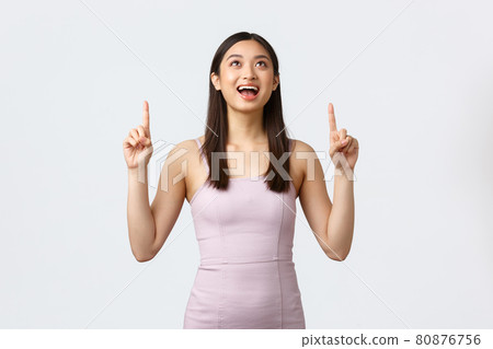 Luxury women, party and holidays concept. Excited and happy smiling pretty asian girl in evening dress, contemplating beautiful firework in sky, pointing fingers up and laughing joyful Luxury women, party and holidays concept. Excited and happy smiling pretty asian girl in evening dress, contemplating beautiful firework in sky, pointing fingers up and laughing joyful 80876756