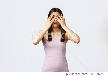 Luxury women, party and holidays concept. Scared timid and insecure pretty asian woman at event in evening dress, witness horrible situation, cover eyes and peeking through fingers frightened Luxury women, party and holidays concept. Scared timid and insecure pretty asian woman at event in evening dress, witness horrible situation, cover eyes and peeking through fingers frightened 80876758