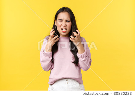 Lifestyle, emotions and advertisement concept. Outraged and pissed-off asian girl looking mad and aggressive clench fists, want kill someone, grimacing angry, standing yellow background Lifestyle, emotions and advertisement concept. Outraged and pissed-off asian girl looking mad and aggressive clench fists, want kill someone, grimacing angry, standing yellow background 80880228
