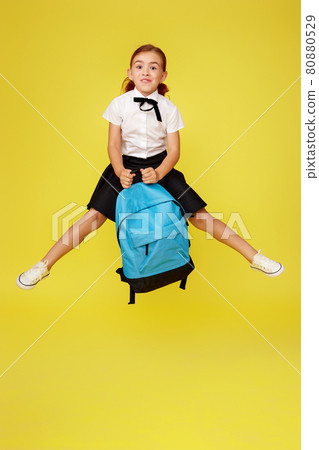 cute happy schoolgirl jumping up with backpack cute happy schoolgirl jumping up with backpack 80880529