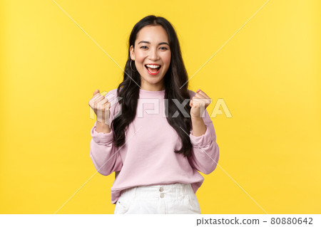 Lifestyle, emotions and advertisement concept. Cheerful and excited cute asian girl winning lottery, feel luck and upbeat, triumphing over achievement, say yes and fist pump rejoicing Lifestyle, emotions and advertisement concept. Cheerful and excited cute asian girl winning lottery, feel luck and upbeat, triumphing over achievement, say yes and fist pump rejoicing 80880642