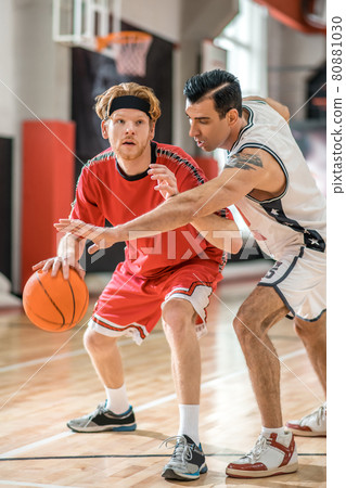 Two young men playing basketball and looking excited 80881030