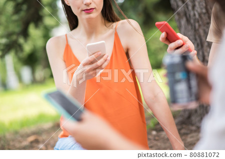 Young people focused on their smartphones in nature Young people focused on their smartphones in nature 80881072