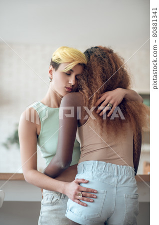 Woman with short hair hugging african american girlfriend Woman with short hair hugging african american girlfriend 80881341