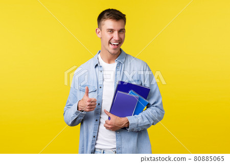 Education, courses and university concept. Excited happy handsome male student, college guy enjoying studying at law school, showing thumbs-up, carry notebooks and study material 80885065
