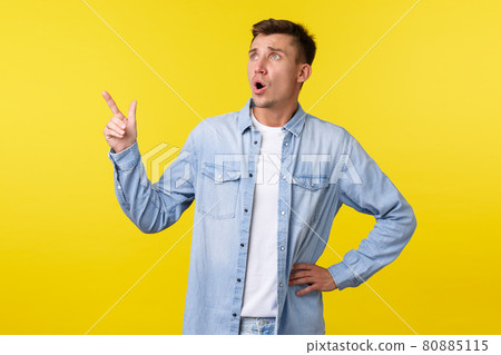 Upset and frustrated handsome blond man frowning, pointing and looking upper left corner with disappointed sad face, grimacing over failure or bad news on banner, yellow background Upset and frustrated handsome blond man frowning, pointing and looking upper left corner with disappointed sad face, grimacing over failure or bad news on banner, yellow background 80885115