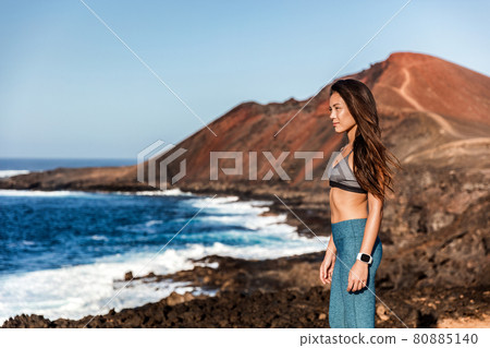 Sports watch fitness runner woman looking at ocean view from mountain landscape during outdoor run workout. Asian athlete girl training outside in summer. 80885140