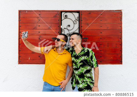 Happy friends taking selfie on street 80886515