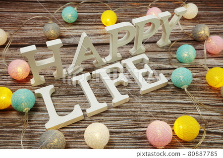 Happy Life alphabet letter with LED cotton balls on wooden background Happy Life alphabet letter with LED cotton balls on wooden background 80887785