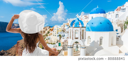 Travel vacation europe summer holidays tourist woman looking at Greek Santorini famous attraction wearing white hat. Banner panoramic landscape. 80888841